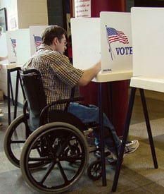 Andrew Carr casts a paper ballot in a conventional voting booth.