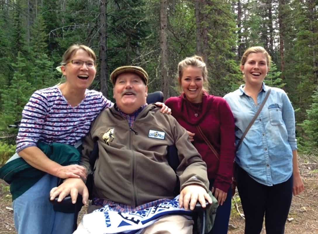 Bev and Bryan are shown with Rachel and Alicia, two of many Cal Poly State University students who’ve served as part-time caregivers. Bev says they become like family and often come along on trips to help with Bryan’s personal assistance.