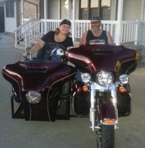 Lou Ann Kibbee wheels into the sidecar of her husband’s Harley.