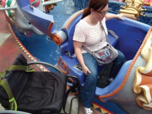 Disney enthusiast and vacation planner Melissa Knight demonstrates transferring from her manual wheelchair to Dumbo the Flying Elephant.