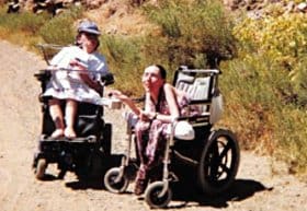Johnson enjoys the mountains of Colorado with fellow disability activist and writer Laura Hershey. "The life of a butt wipee is interesting, adventurous, eventful," she often says.