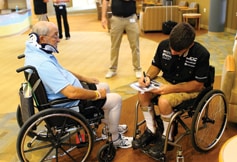 Up-and-coming racer Michael Johnson signs an autograph at a rehab center.
