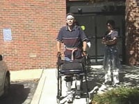 Home from China, Landewee tries out braces and a walker following OEG treatment.
