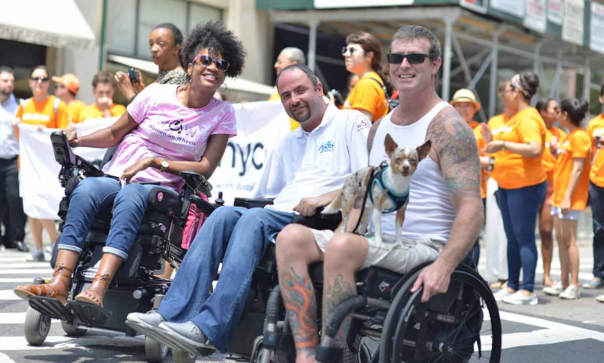 Elegudin represents Axis and Wheeling Forward at the 2015 Disability Pride Parade.