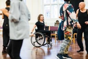 Women in black using wheelchair in rehearsal for casting in Taming of the Shrew