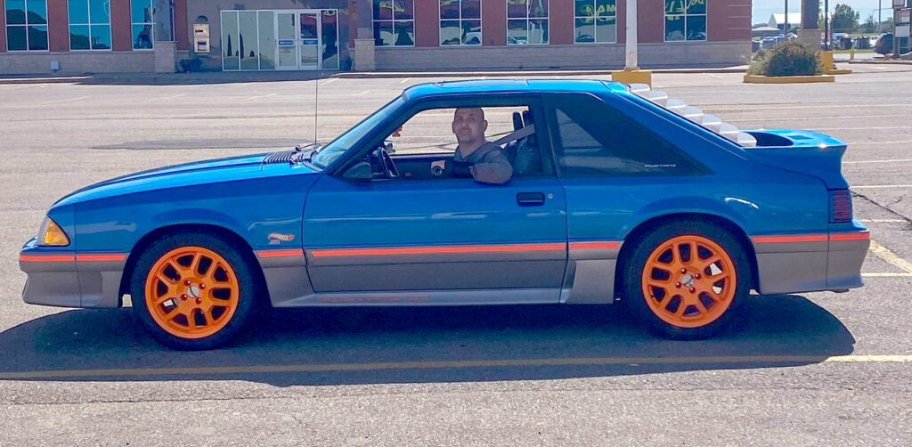 Landon sitting in his Mustang.