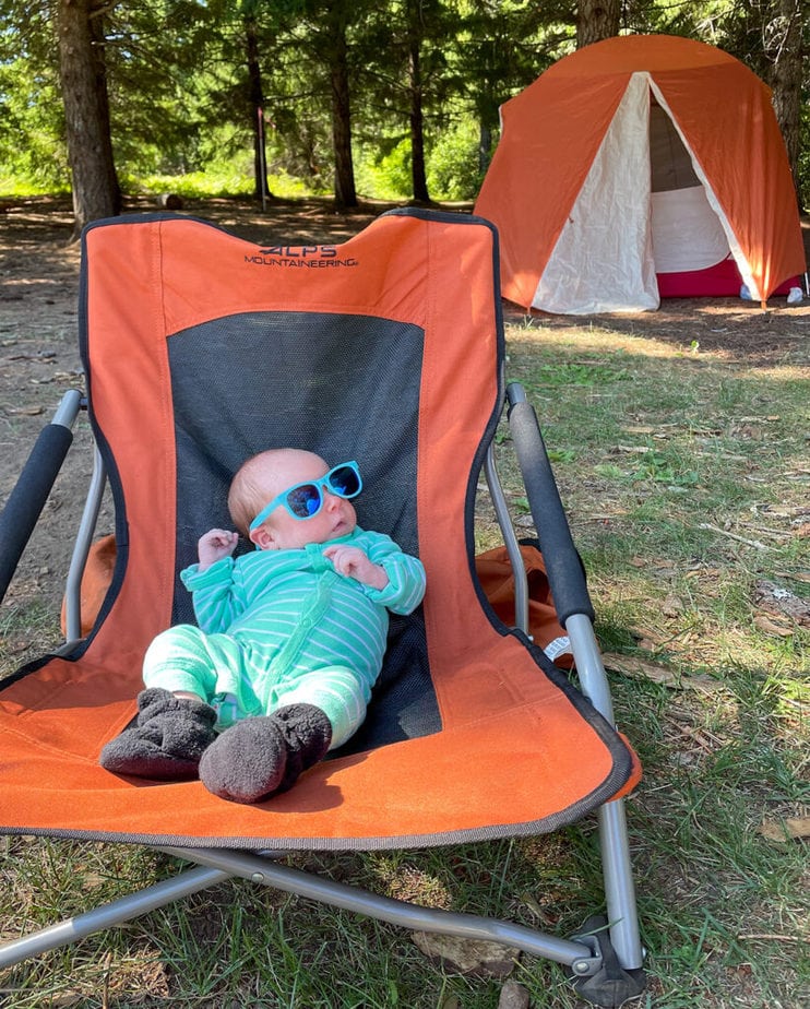 Baby Lou wearing sunglasses, laying in a folding chair outside.