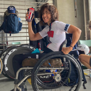 USA paralympic athlete Alicia Dana in sports wheelchair hold water bottle
