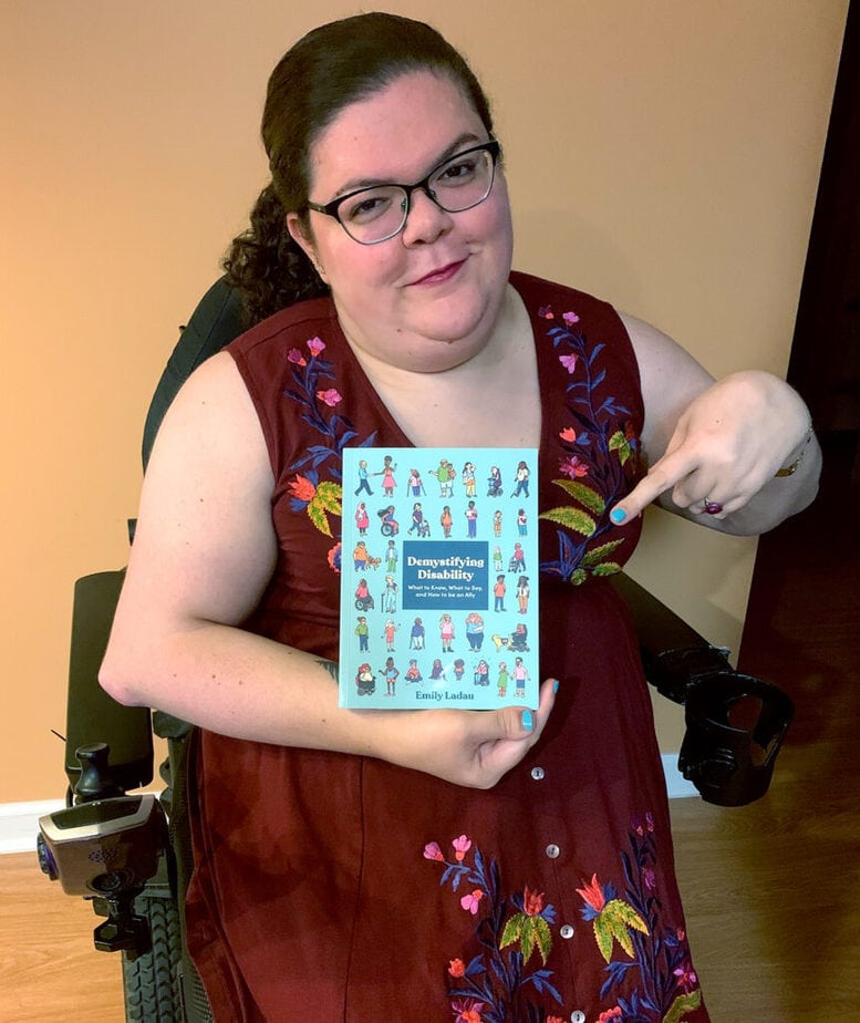 Emily Ladau holding her new book Demystifying Disability
