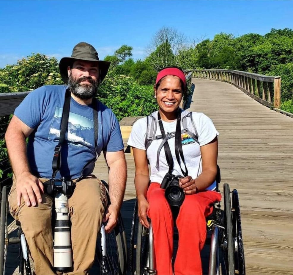 man and woman in wheelchairs on wooden pathway
