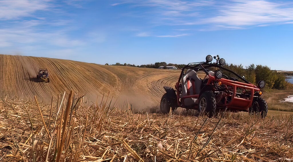 two quads in ATVs tearing up a field