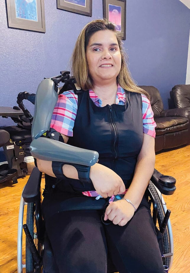 woman in wheelchair wearing orthotic device on arm