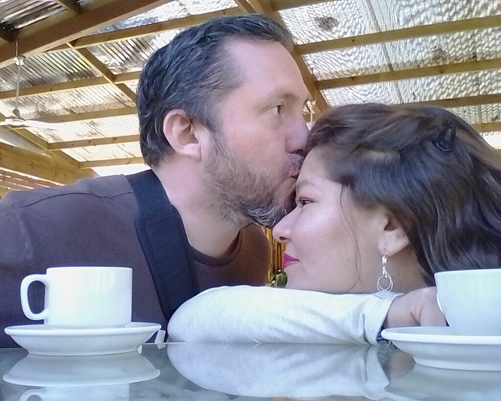 man kissing woman on the forehead