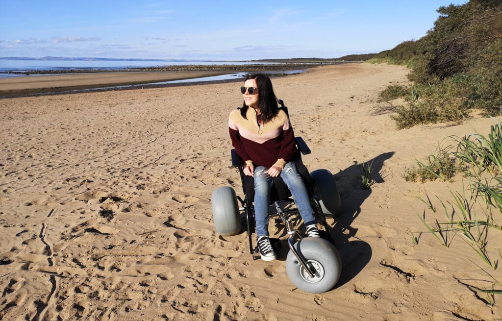 woman on the beach in a beach wheelchair