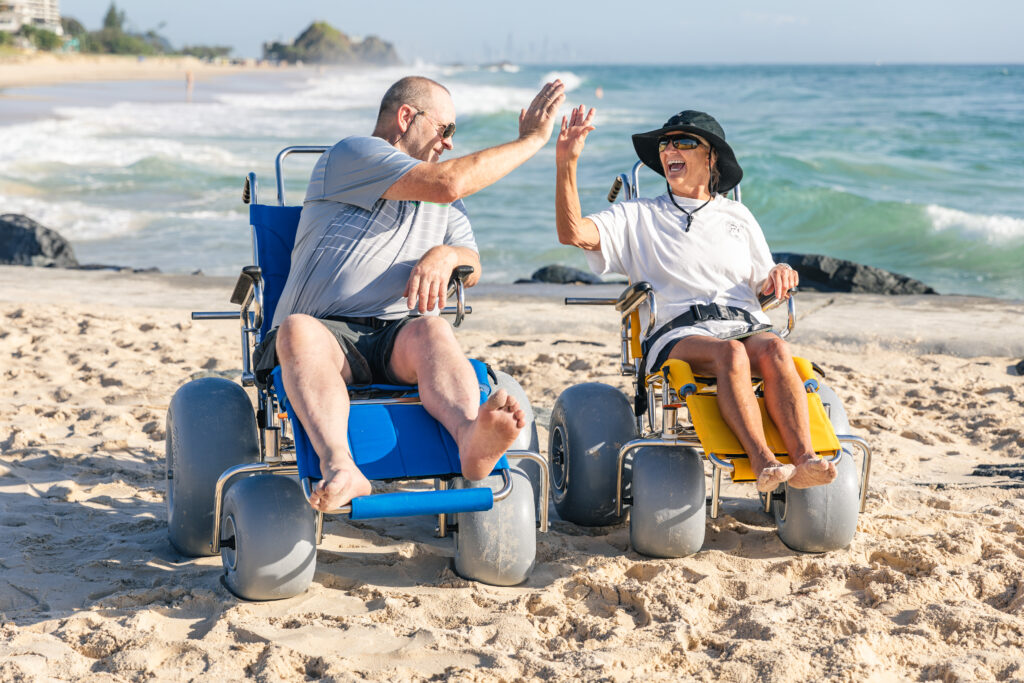 man and woman in beach wheelchairs oceanside