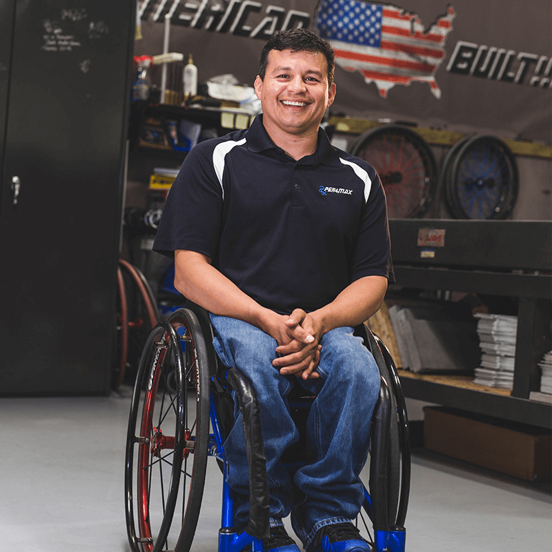 man sitting in wheelchair with wheelchair equipment in background
