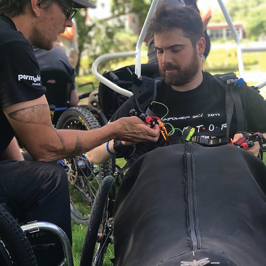 One of Stone’s passions is getting other people with SCIs into the sky, as shown here assisting another paraglider