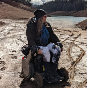 woman in powerchair in front of lake
