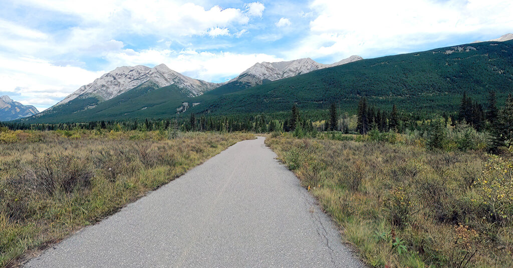 empty rural road with mountains in background