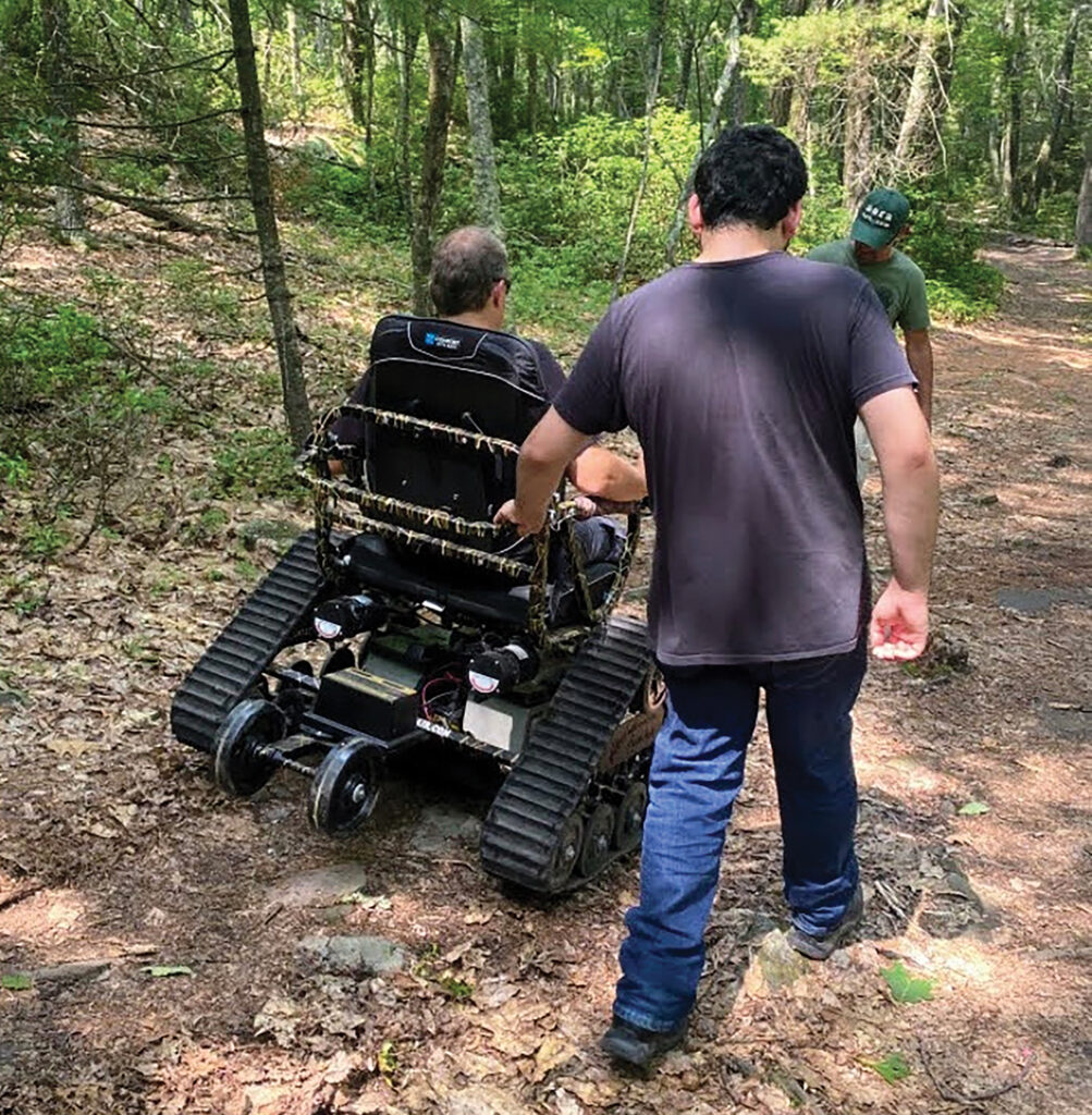 man driving an all-terrain chair with tracks instead of wheels