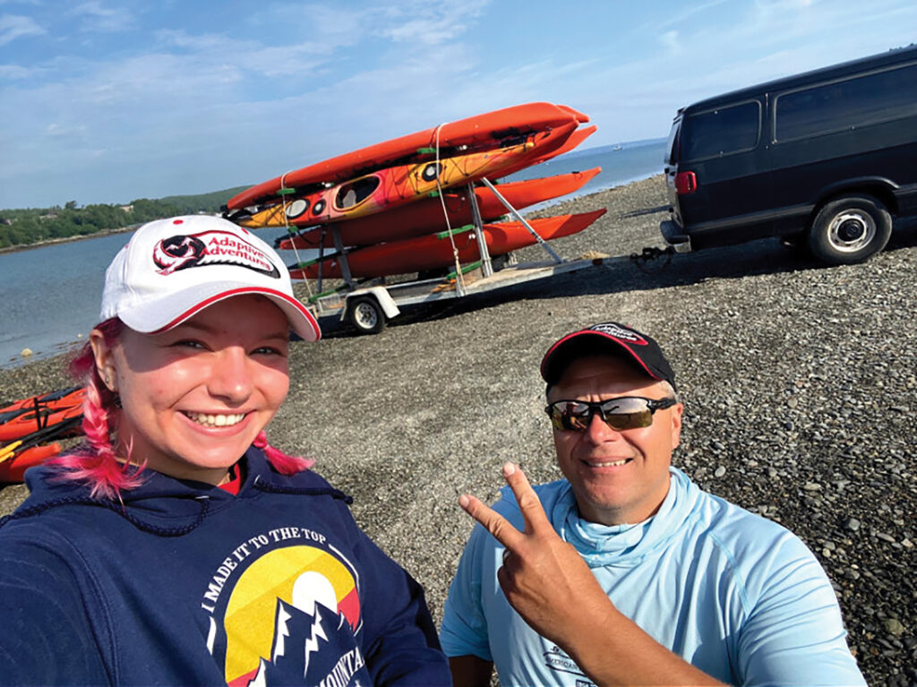 selfie of author with daugher with kayaks in background