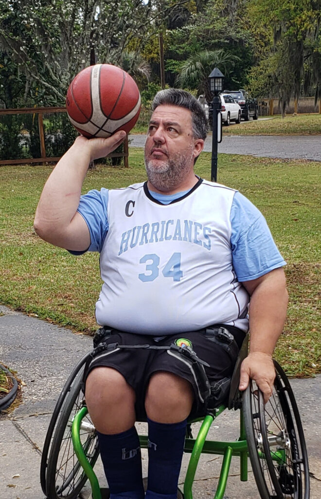 man in sports wheelchair shooting a basketball