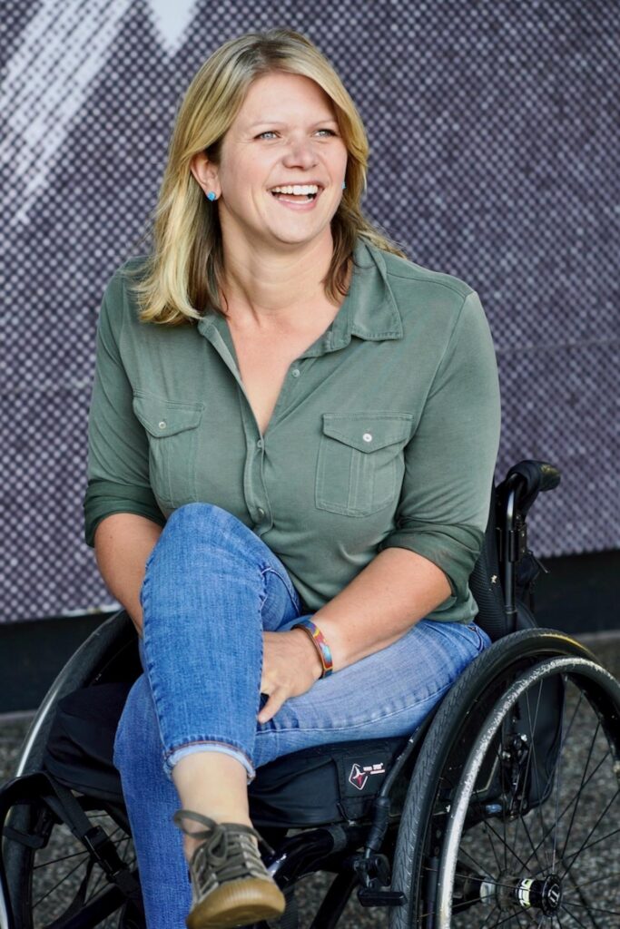Full length image of Regan sitting in chair smiling
