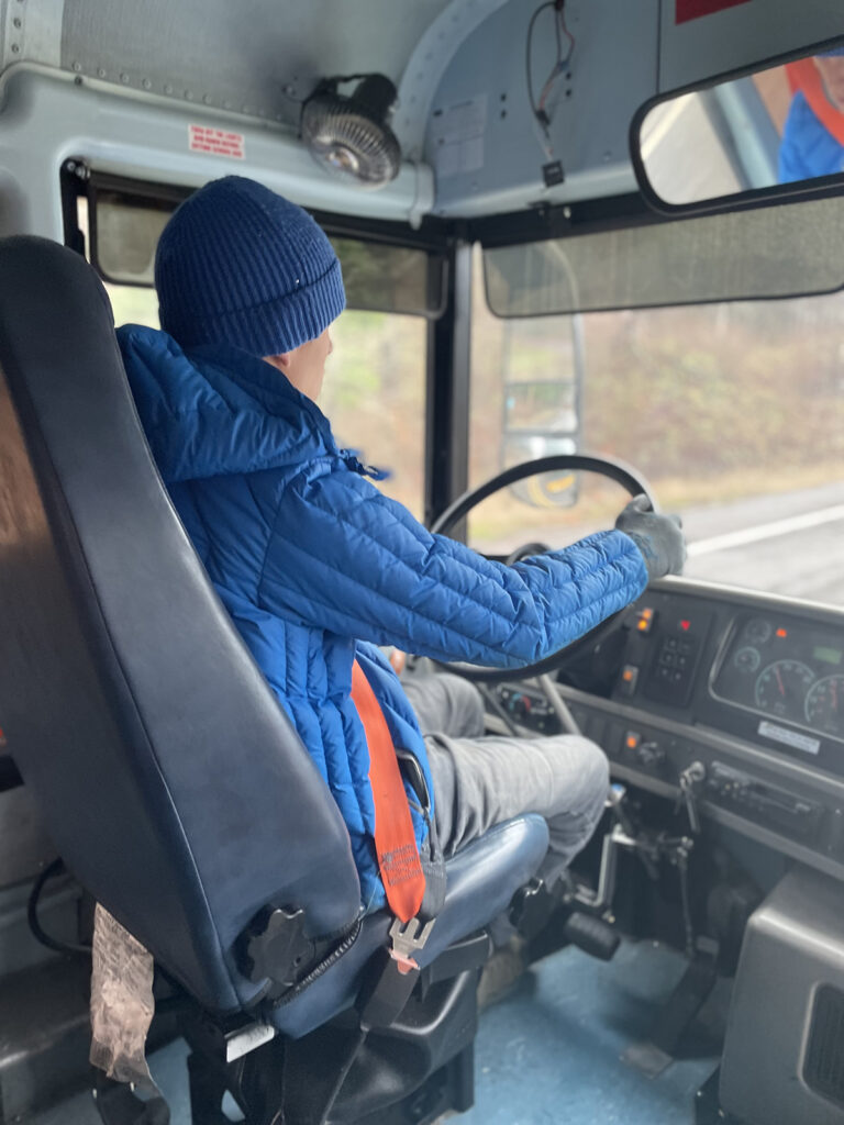 The author pictured behind the wheel driving bus