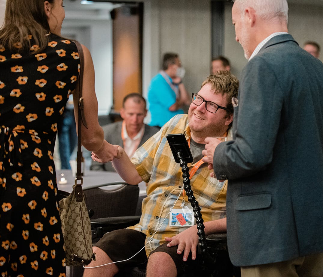man in wheelchair shaking hands with woman 