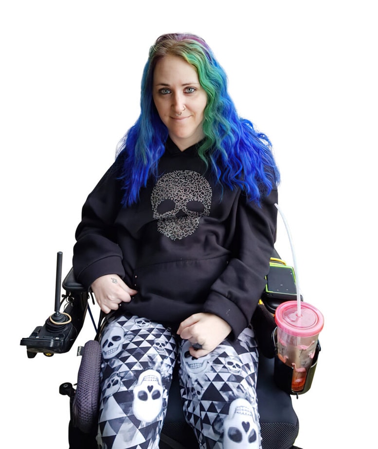woman with various shades of long blue hair sitting in powerchair