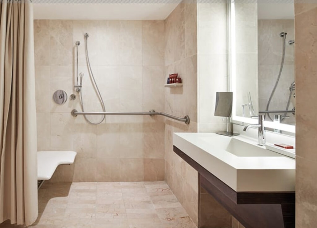 a modern accessible hotel bathrom with open roll-in shower