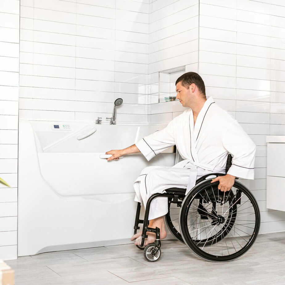 Assisto bathtub shown with wheelchair user