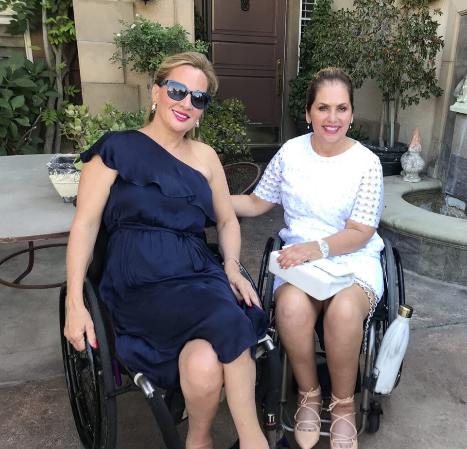 two dressed up women in wheelchairs outside on patio