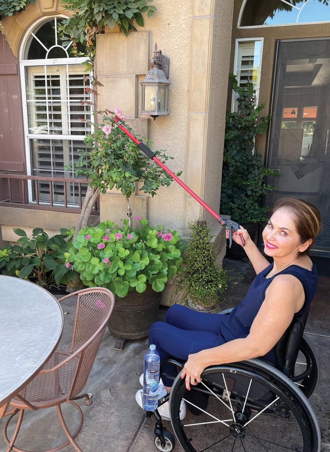 woman in wheelchair using a reaacher inoutdoor patio