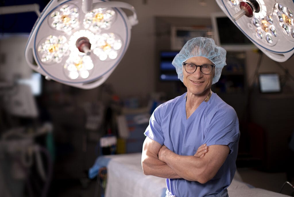 surgeon with arms crossed posed for camera in operation room