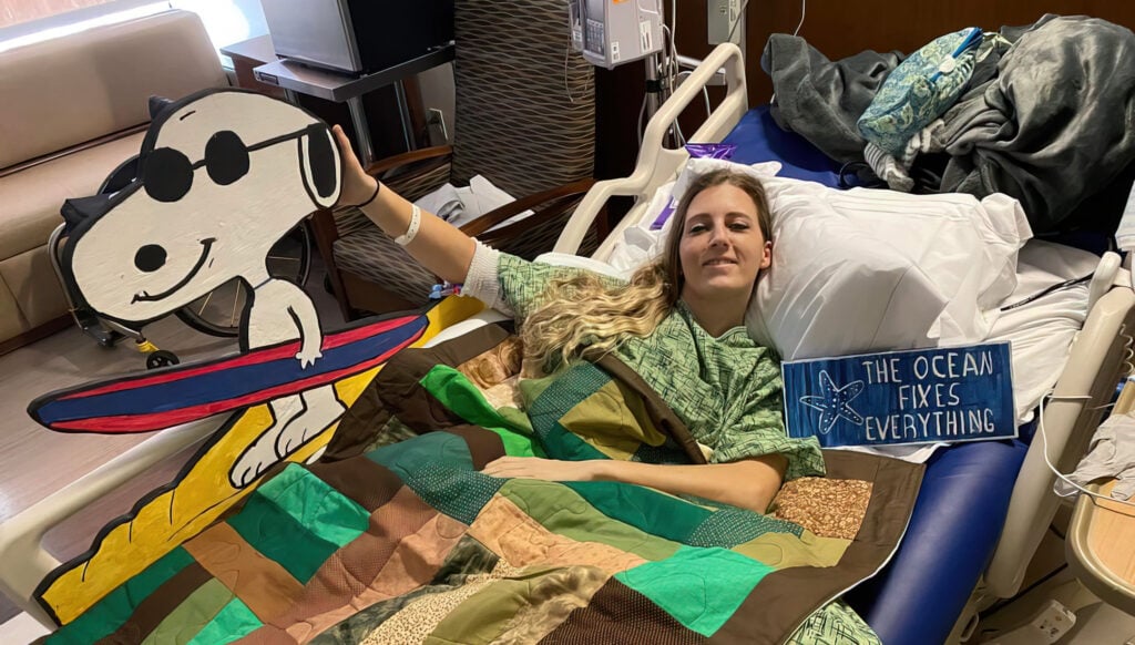 smiling woman in hospital bed with Snoopy cut out