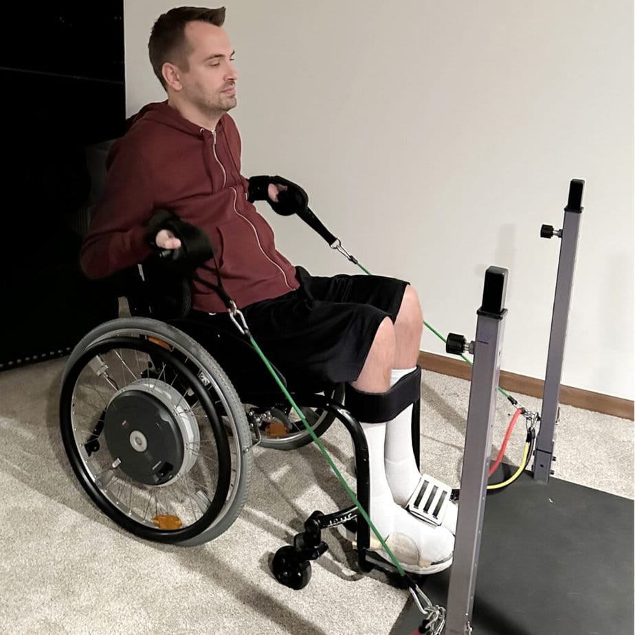Man in wheelchair using resistance bands to work out.