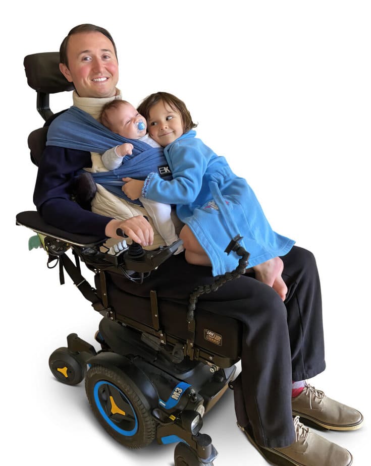 father in power wheelchair with two small children in his lap