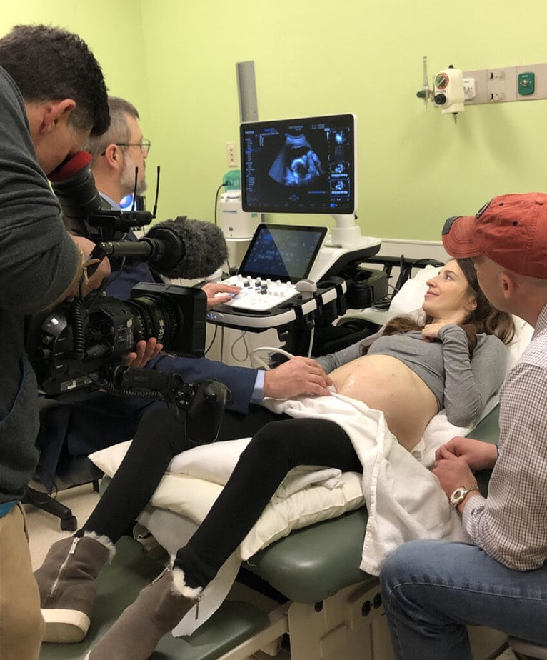 pregnant woman having an ultrasound being filmed by cameraman