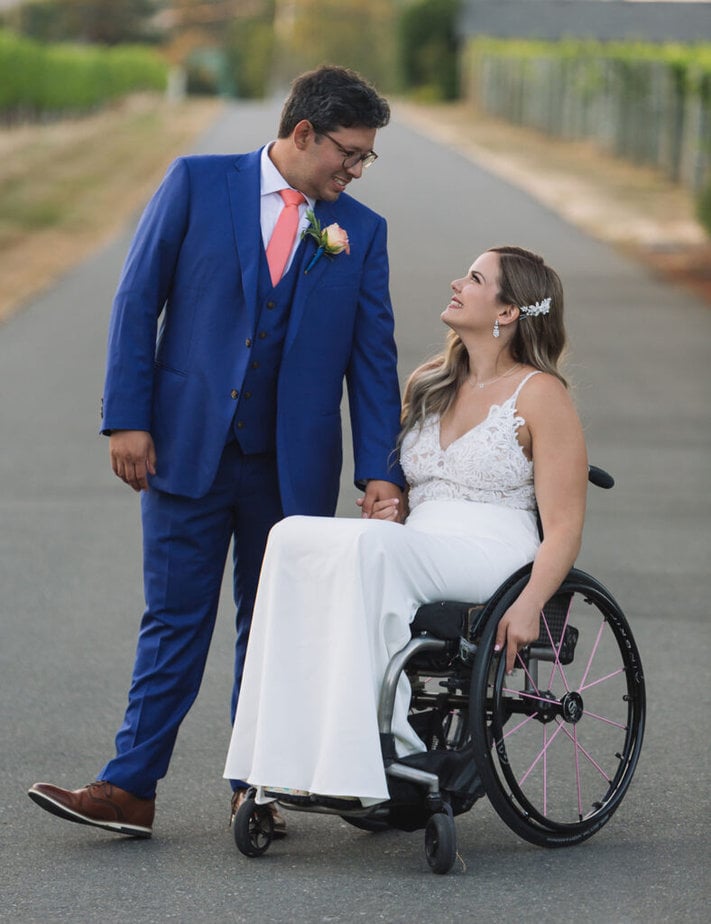 wedding photo, bride in wheelchair, groom wearing blue suit