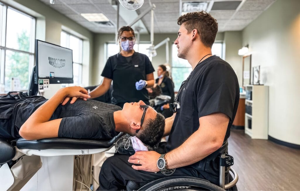 dentist in wheelchair working on patient 