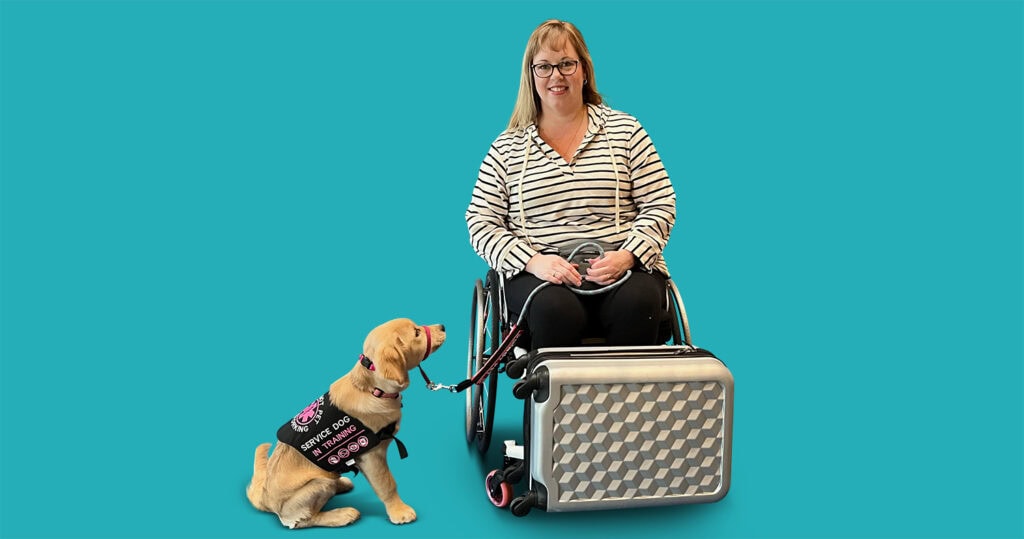 service dog looking woman in wheelchair with suitcase