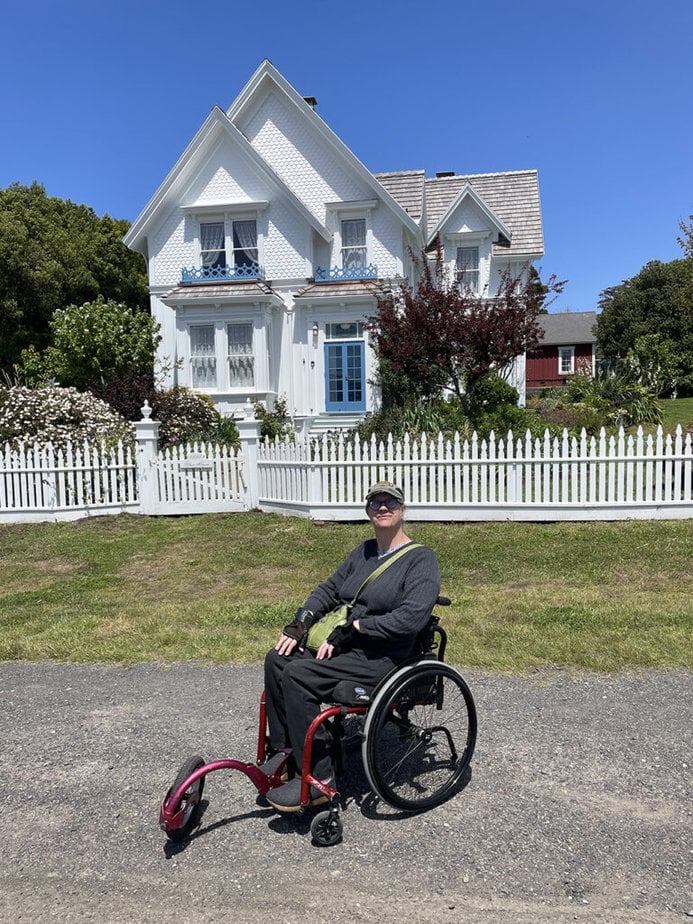 author pictured in front of quaint cottage