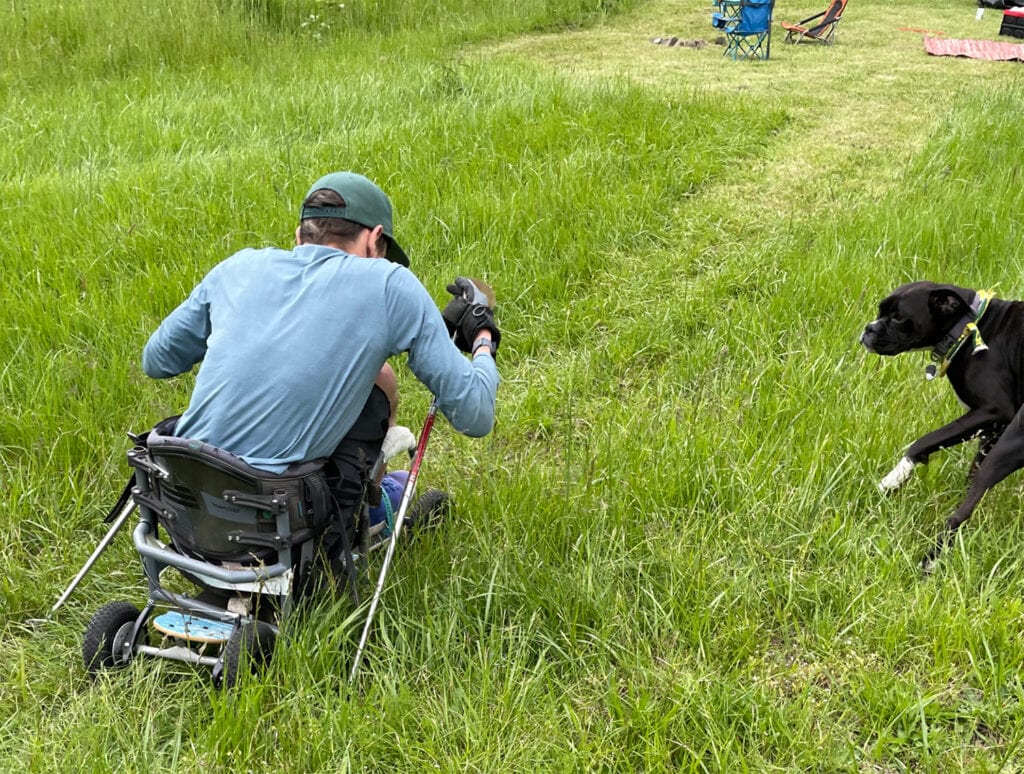 dog watching a man using an adaptive skateboard