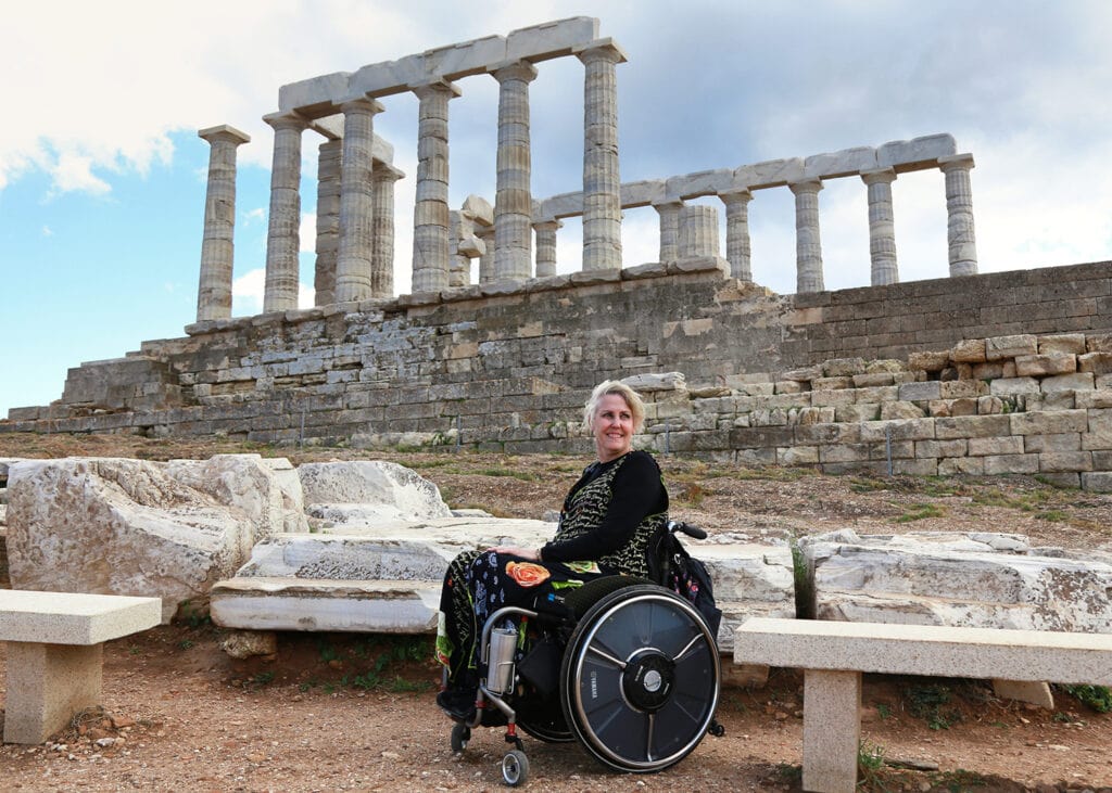 woman in wheelchair in front of Greek ruins