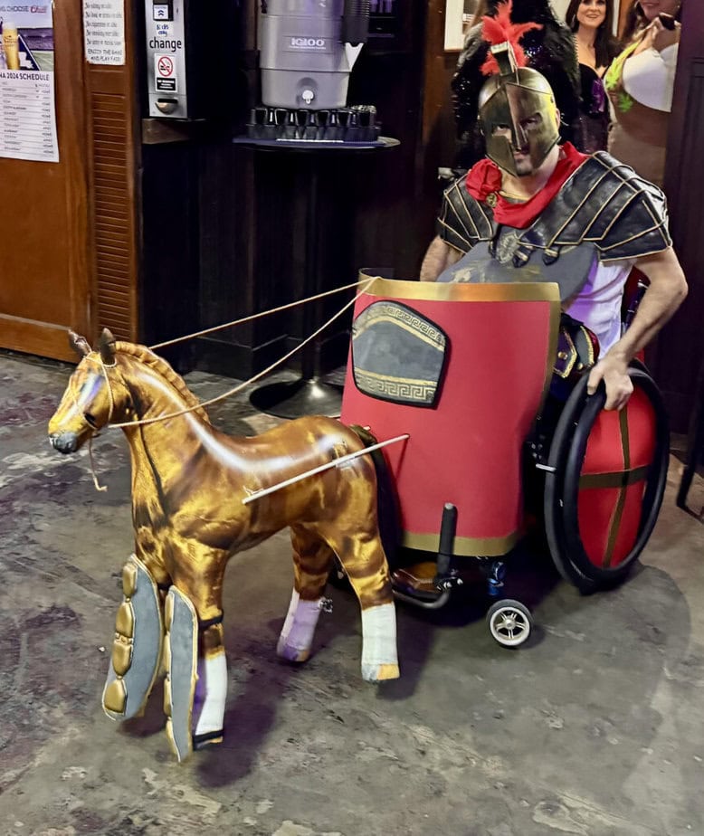 Man in wheelchair wearing Gladiator Halloween costume.  