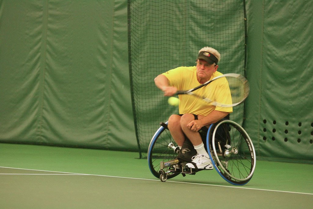 man playing wheelchair tennis