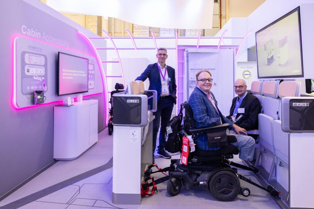 Man in powerchair receiving a demonstration of new aircraft seating  