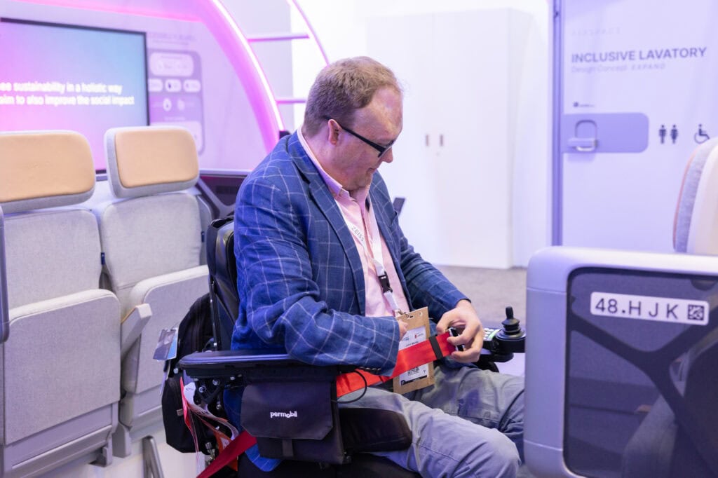 man in powerchair adjusting seatbelt