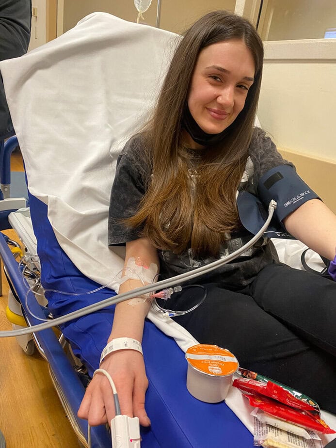 Young woman on hospital bed getting blood drawn